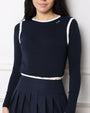Woman wearing a navy blue Tshirt with white trim on a white background