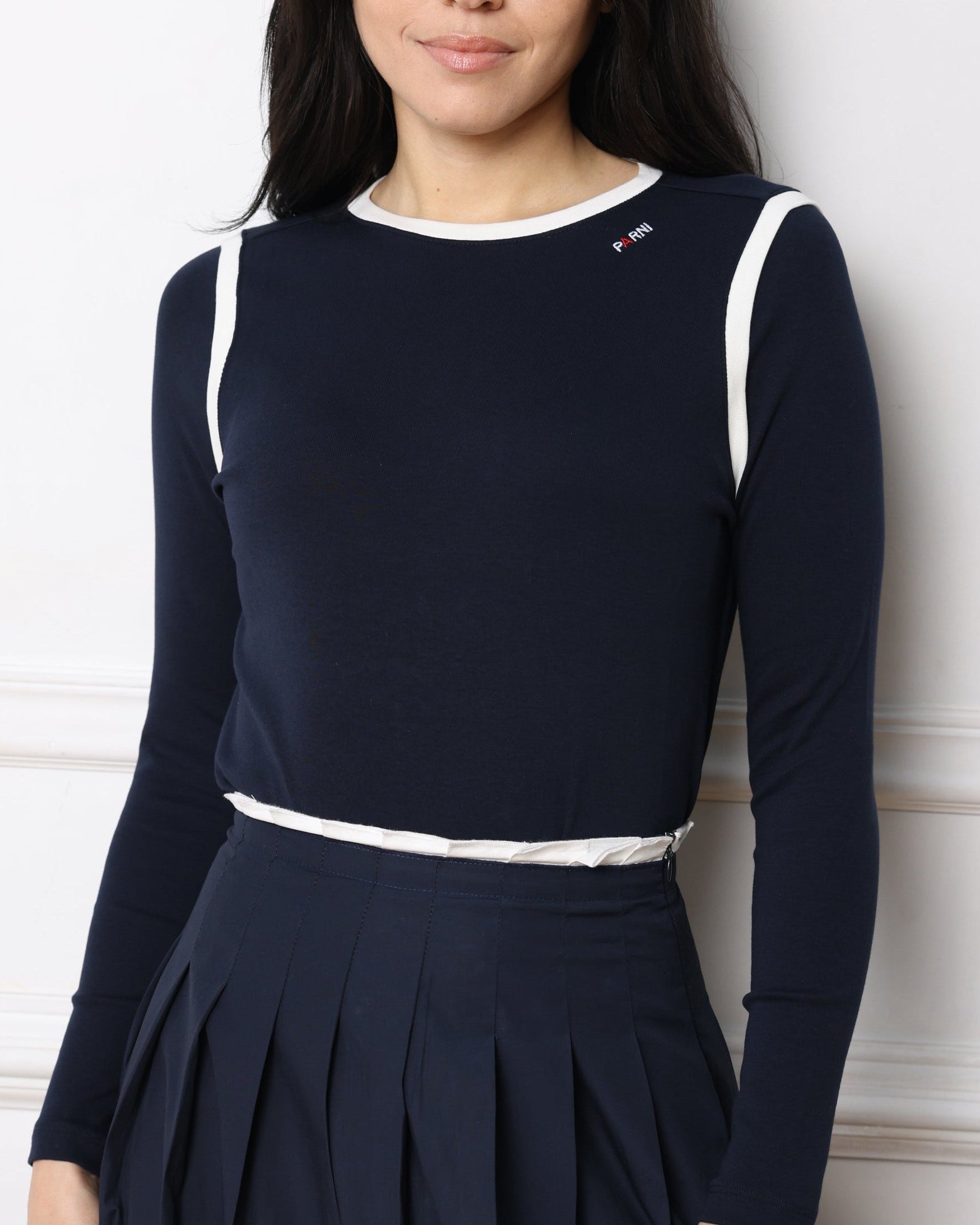 Woman wearing a navy blue Tshirt with white trim on a white background