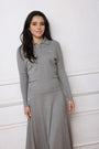 Woman wearing a gray long-sleeve dress with a small logo on a white background