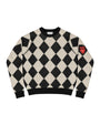 A black and cream argyle knit sweater with a red and black patch on the right sleeve, displayed flat against a checkered transparency-style background.