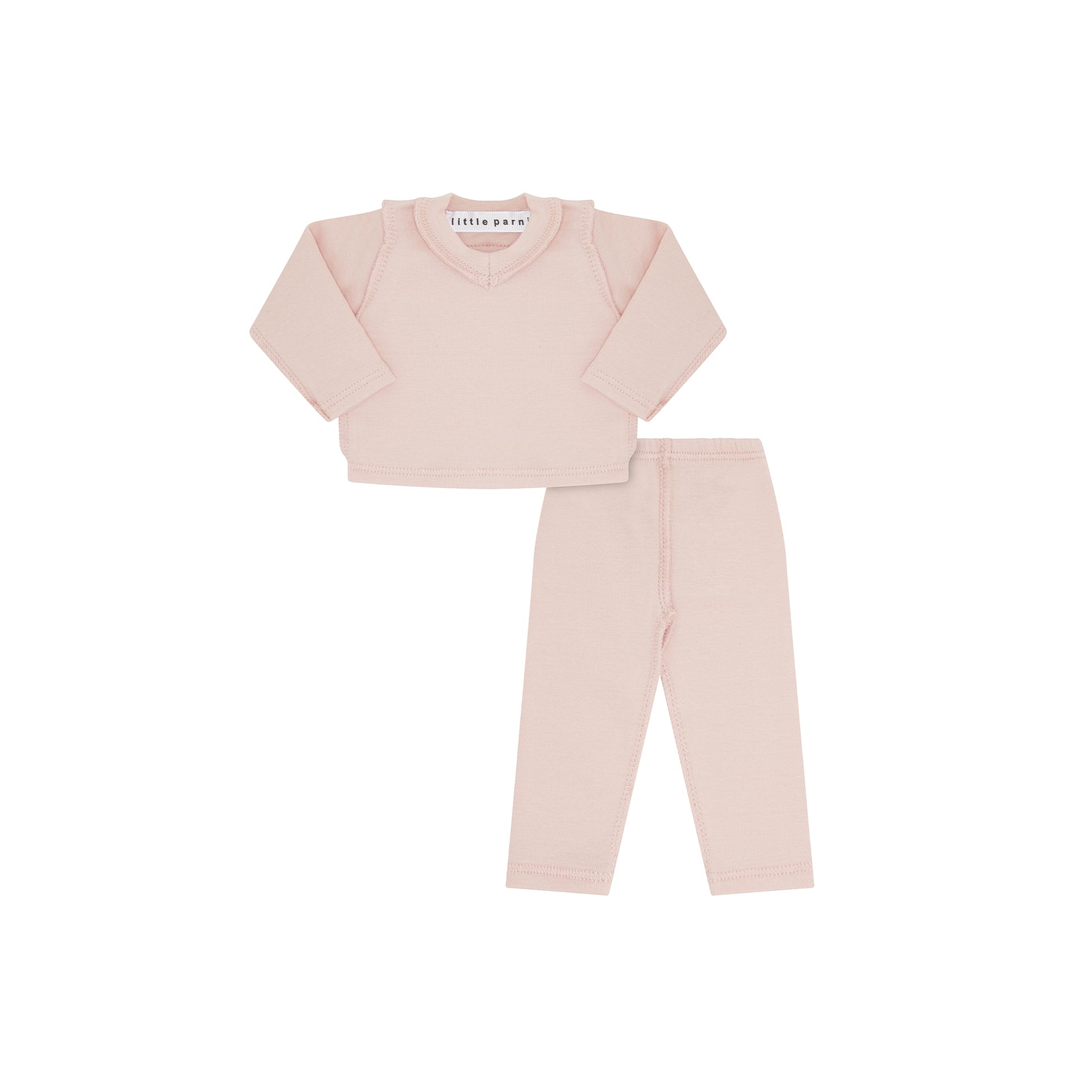 A two-piece doll loungewear set in a soft, pale pink color, featuring a long-sleeve crewneck top and matching pants, laid flat on a white background.