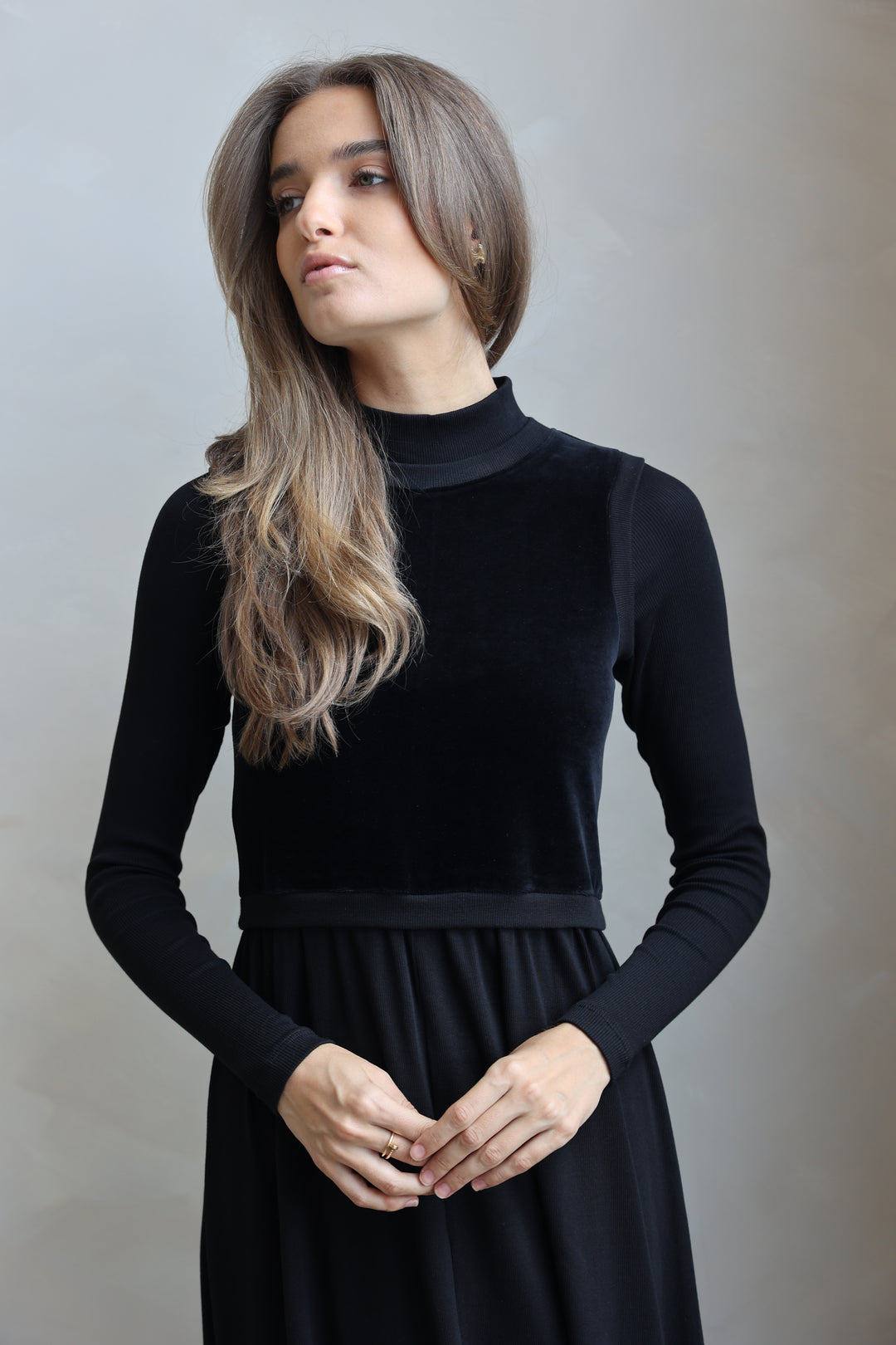 Woman wearing a black dress against a plain background