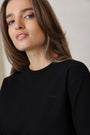 Woman wearing a black top with a blurred background