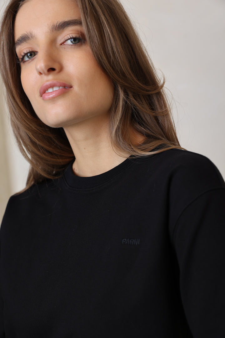 Woman wearing a black top with a blurred background