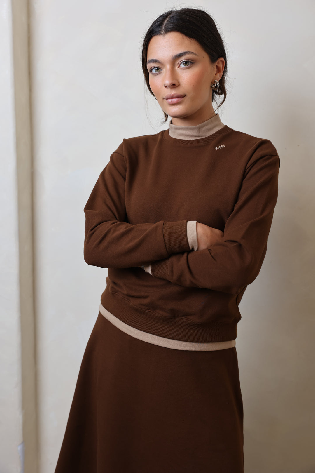 Person wearing a brown outfit with a white background