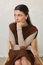 Woman wearing a brown and beige dress lying on a white surface