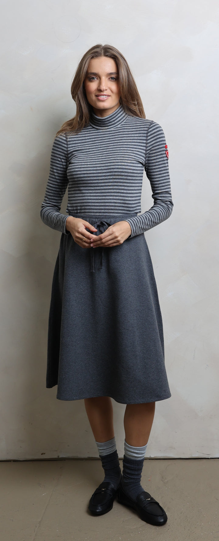 Woman wearing a gray dress with a white background
