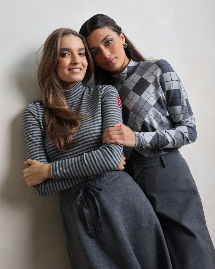 Two people wrapped in a blanket on a plain background