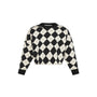 A cropped long-sleeve knit sweater with a black and off-white argyle pattern, featuring solid black ribbed cuffs and collar, shown against a plain white background.