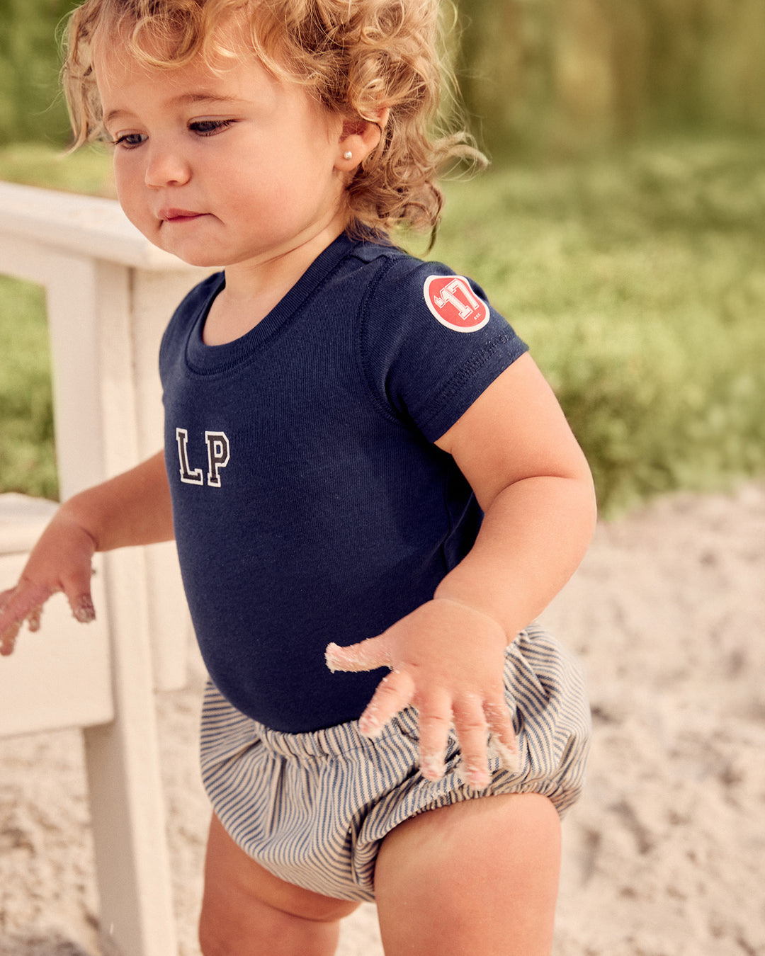 Girl wearing the navy Kids LP Est. Short Sleeve Tee.