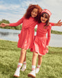 Girls walking outside wearing the LP Pocket Dress and LP skirt and Tee.