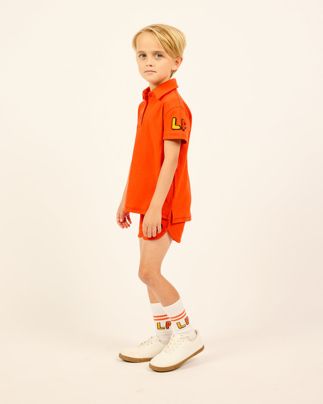 Boy wearing the orange Boys' LP Track Shorts.