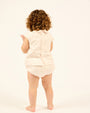 Baby wearing the Two-piece Cotton Set With Bloomers in White, back view.