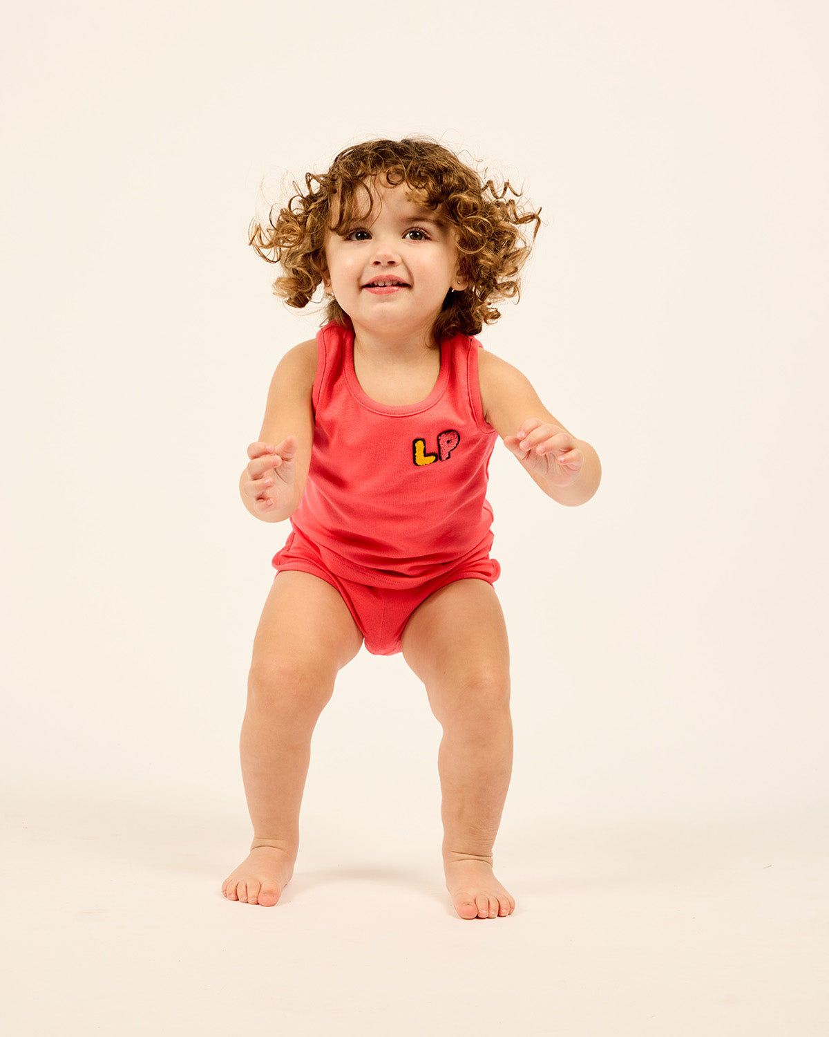 Baby wearing the LP Baby Tank and Short Set in Orange.