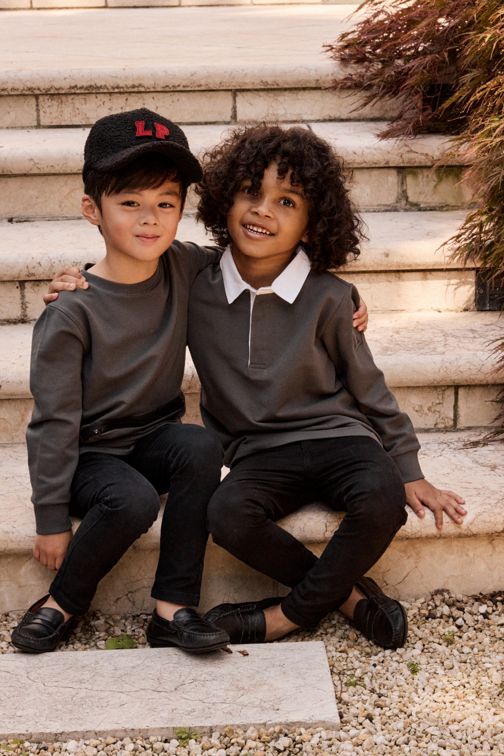 Two children sitting on stone steps outdoors