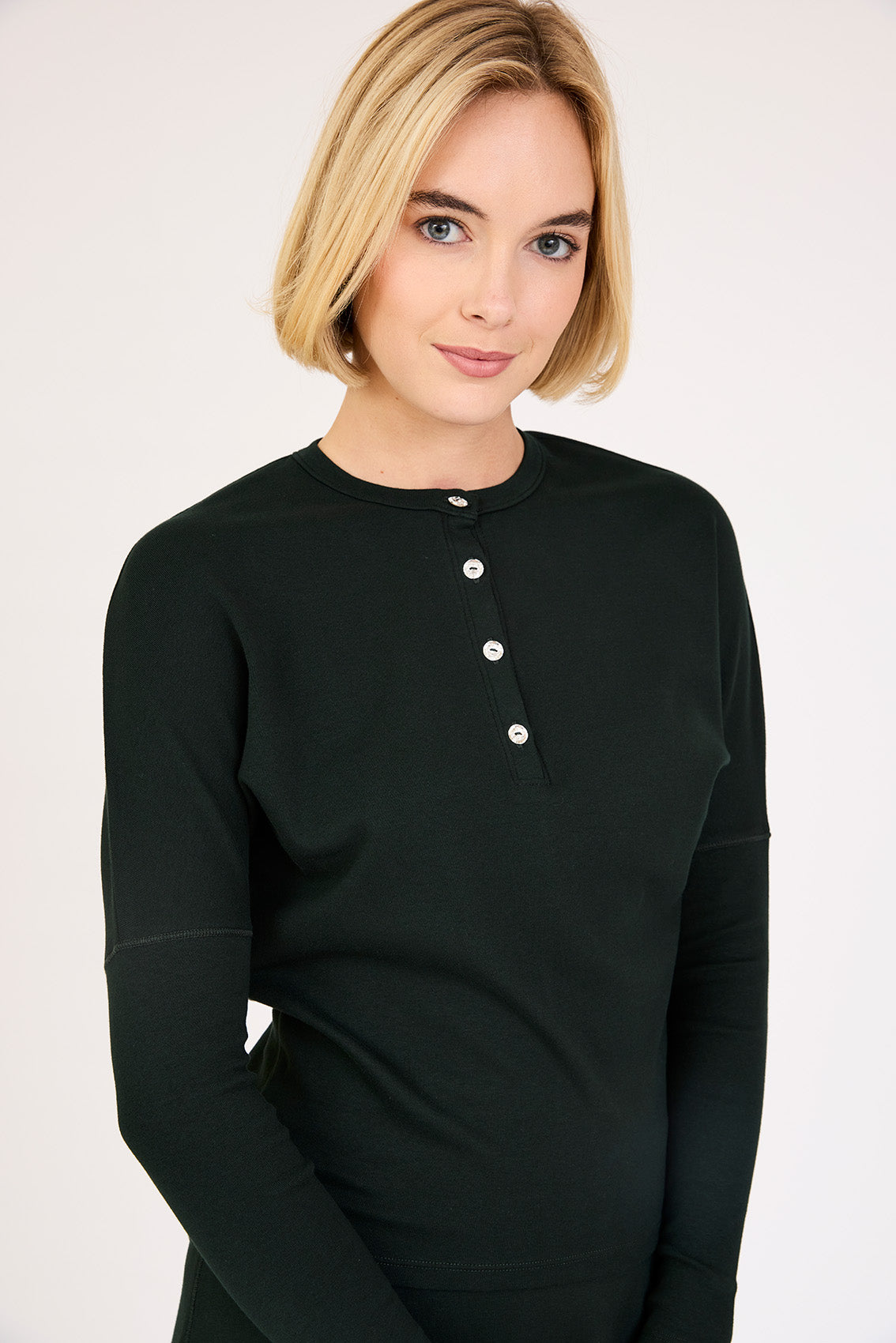 Model wearing the Rhinestone Henley Dolman Sleeve Top in Black.