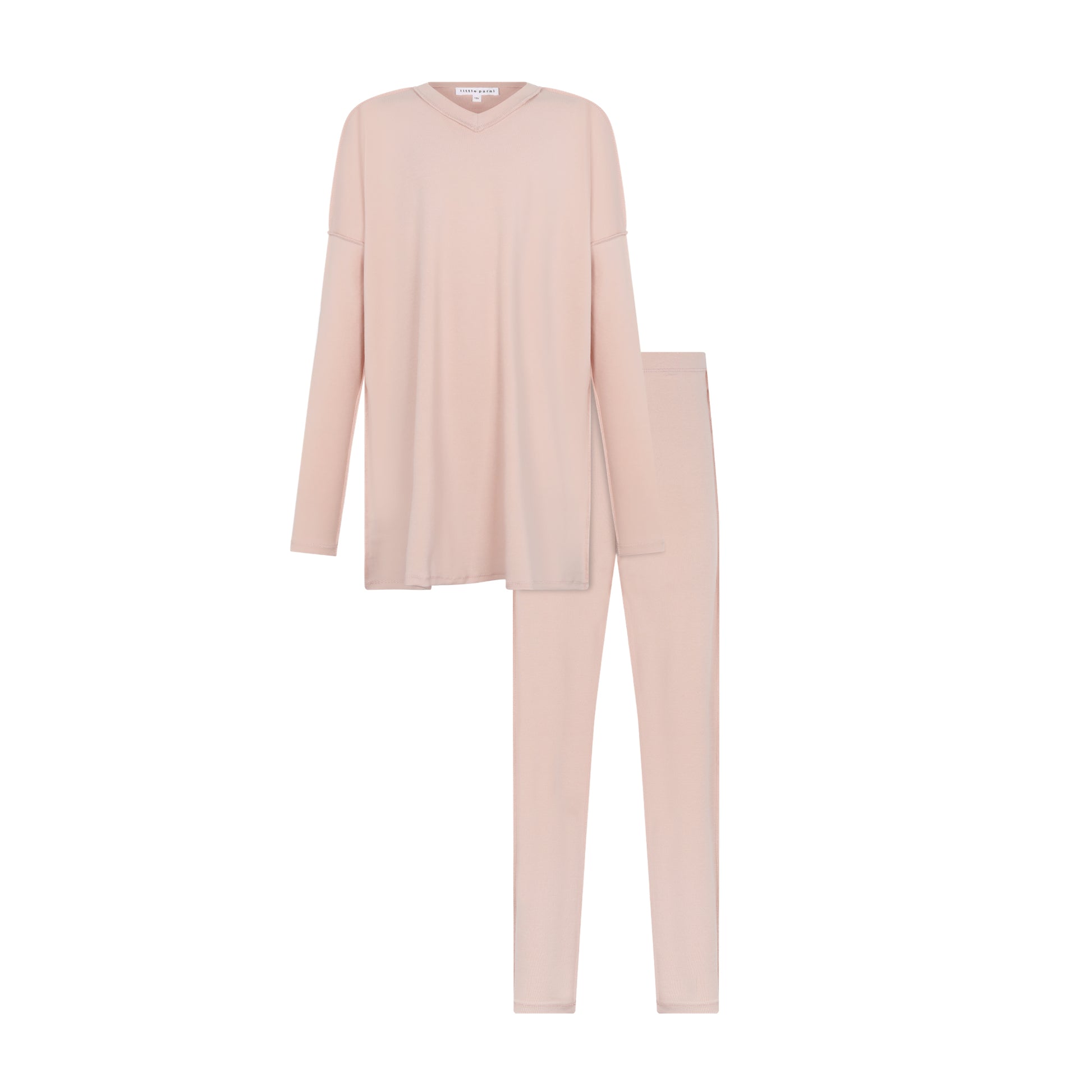 A two-piece pajama set in a soft, pale blush pink, featuring a long-sleeve V-neck top and matching slim-fit pants, displayed on a solid white background.