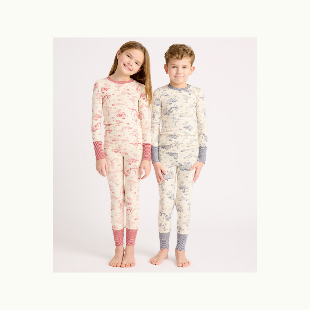 Young girl and boy wearing etoile pattered two piece pajamas, the girl in pink and the boy in light blue