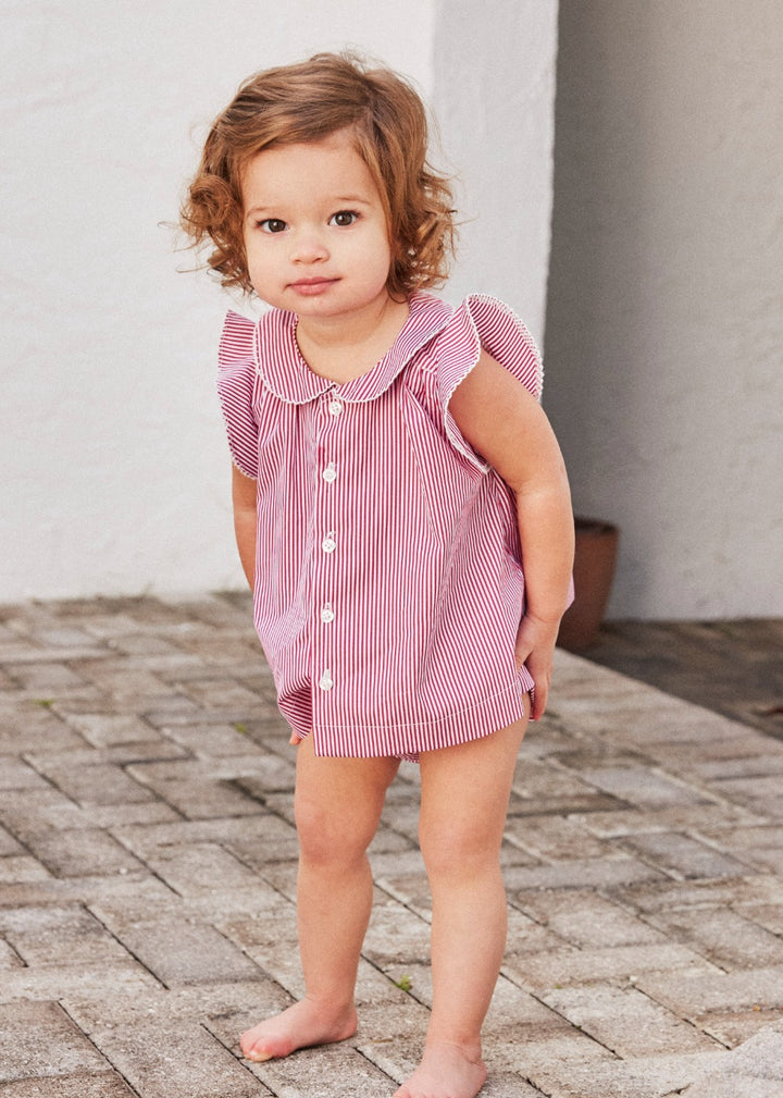 Little girl wearing the Baby Striped Ruffle Tunic & Bloomer Set in pink and white