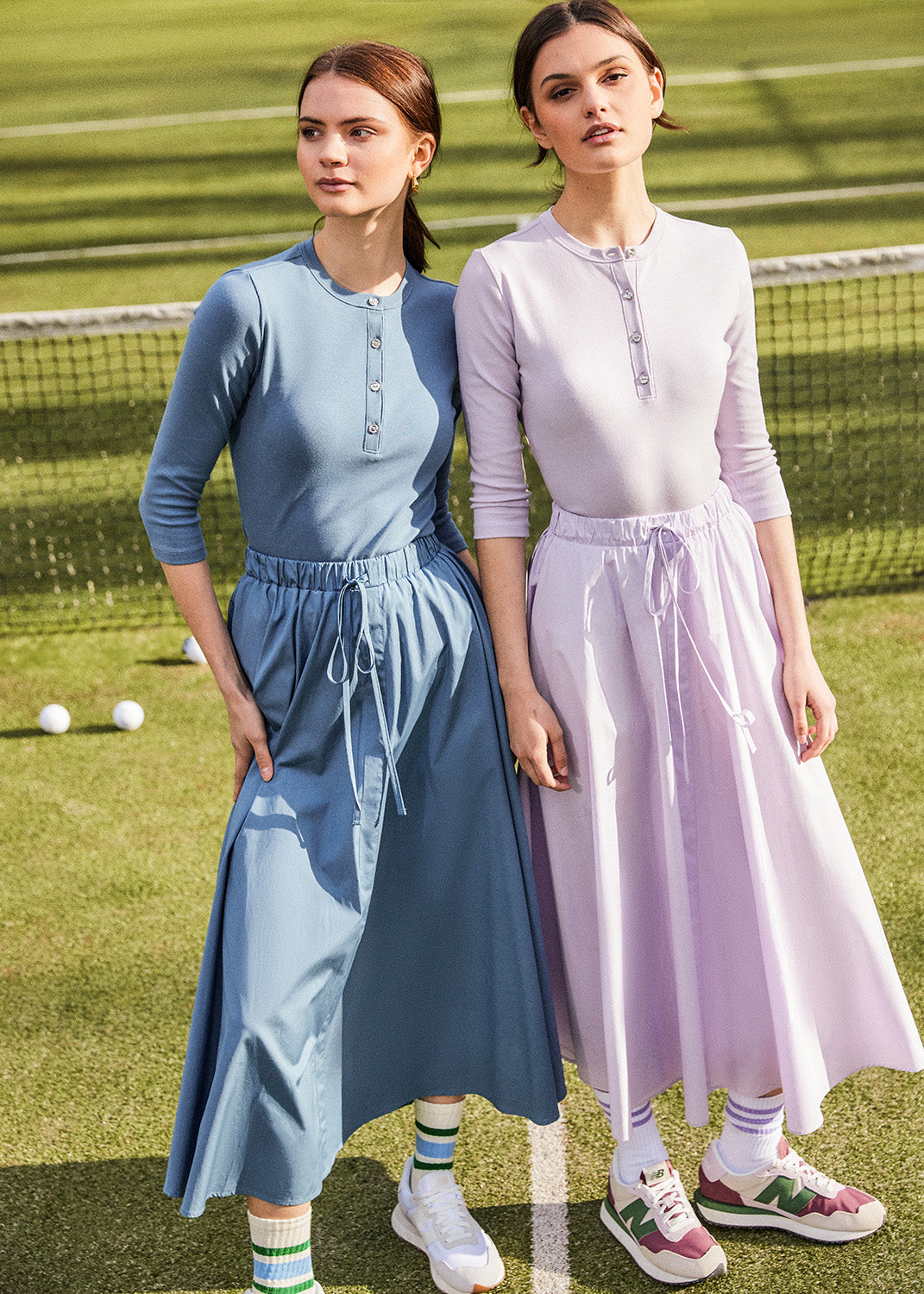 two young women wearing the Rhinestone Long Sleeve Henley with matching midi skirts