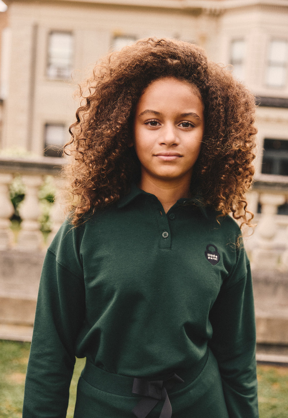Girl wearing the green Girls Collared Sweatshirt
