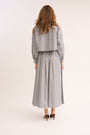 Model turned to show the back of the Striped Poplin Cropped Shirt and skirt.