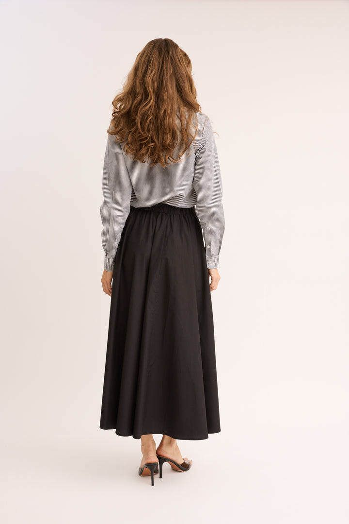 model showing the back of the Relaxed Cotton Drawstring Skirt.
