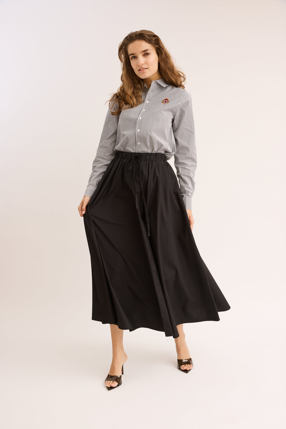 Model wearing the Relaxed Cotton Drawstring Skirt in black with the striped top.