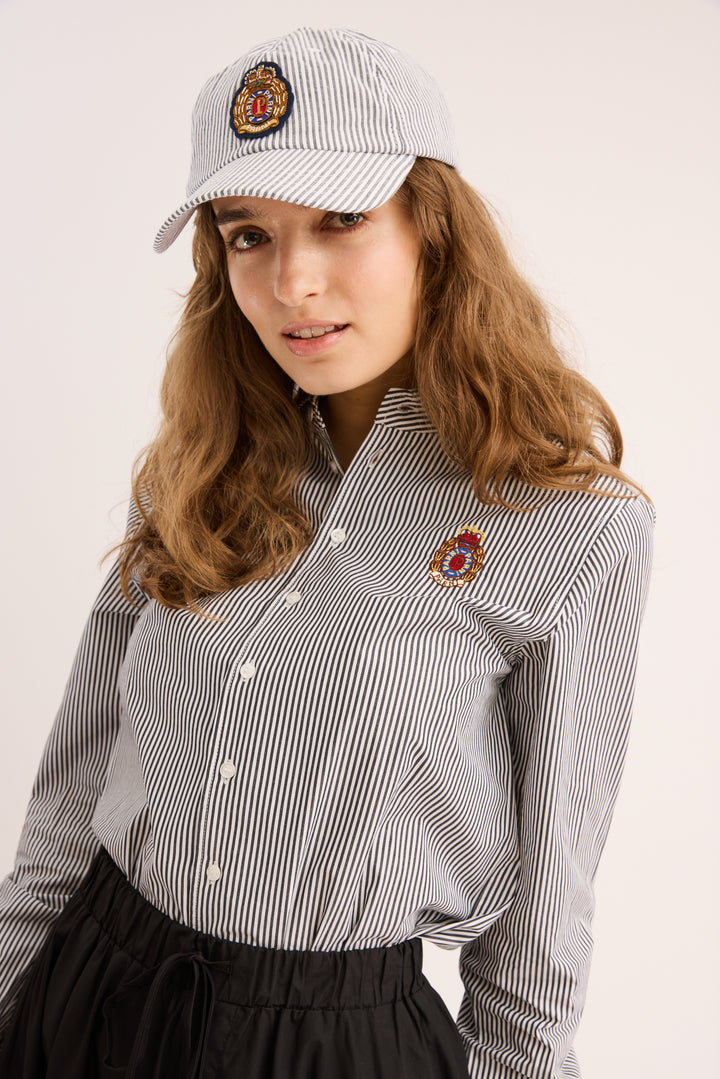 Model wearing the Signature Striped Poplin Shirt with a popling skirt.