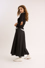 Woman wearing the Classic Elbow Patch Tee with skirt. 