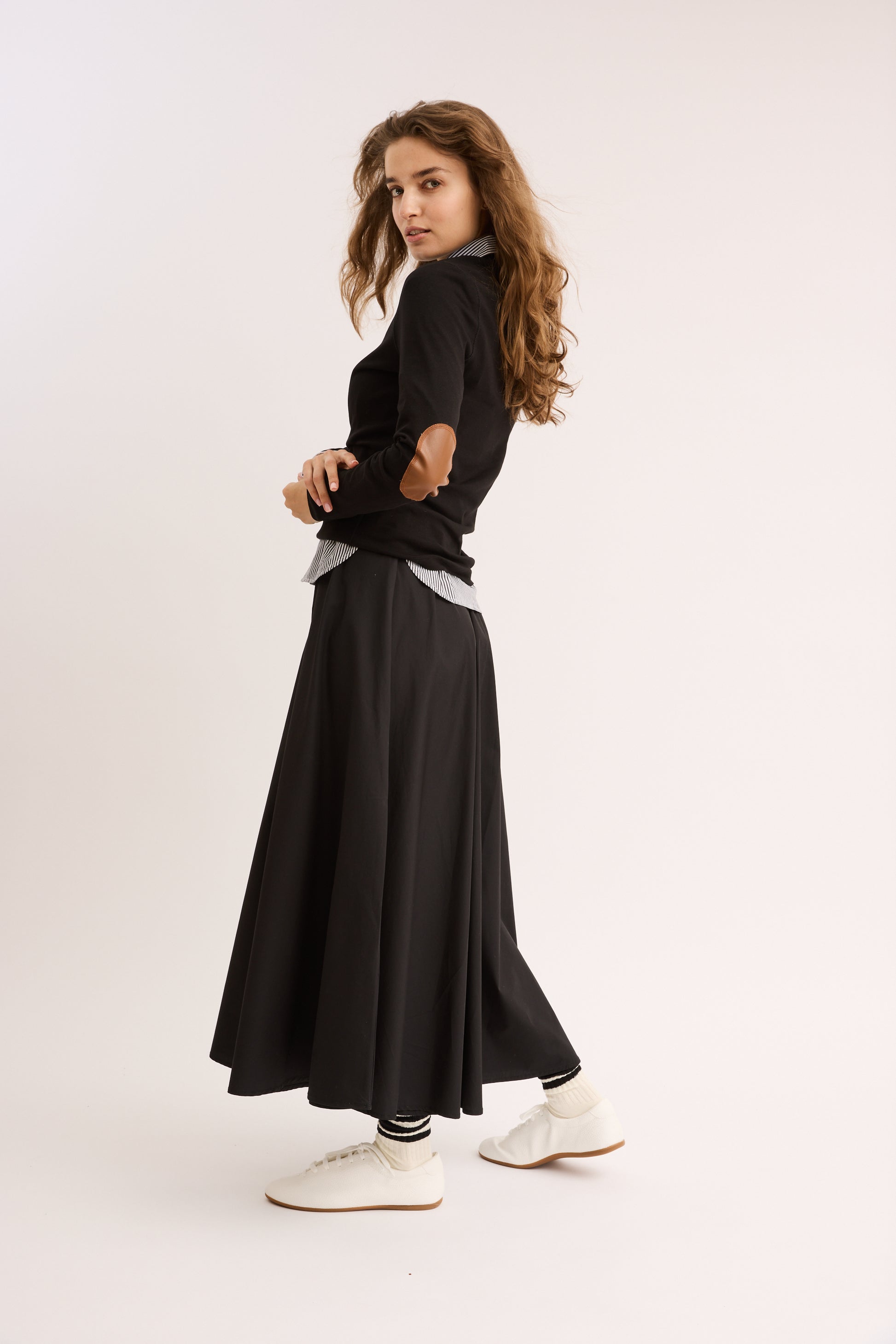 Woman wearing the Classic Elbow Patch Tee with skirt. 