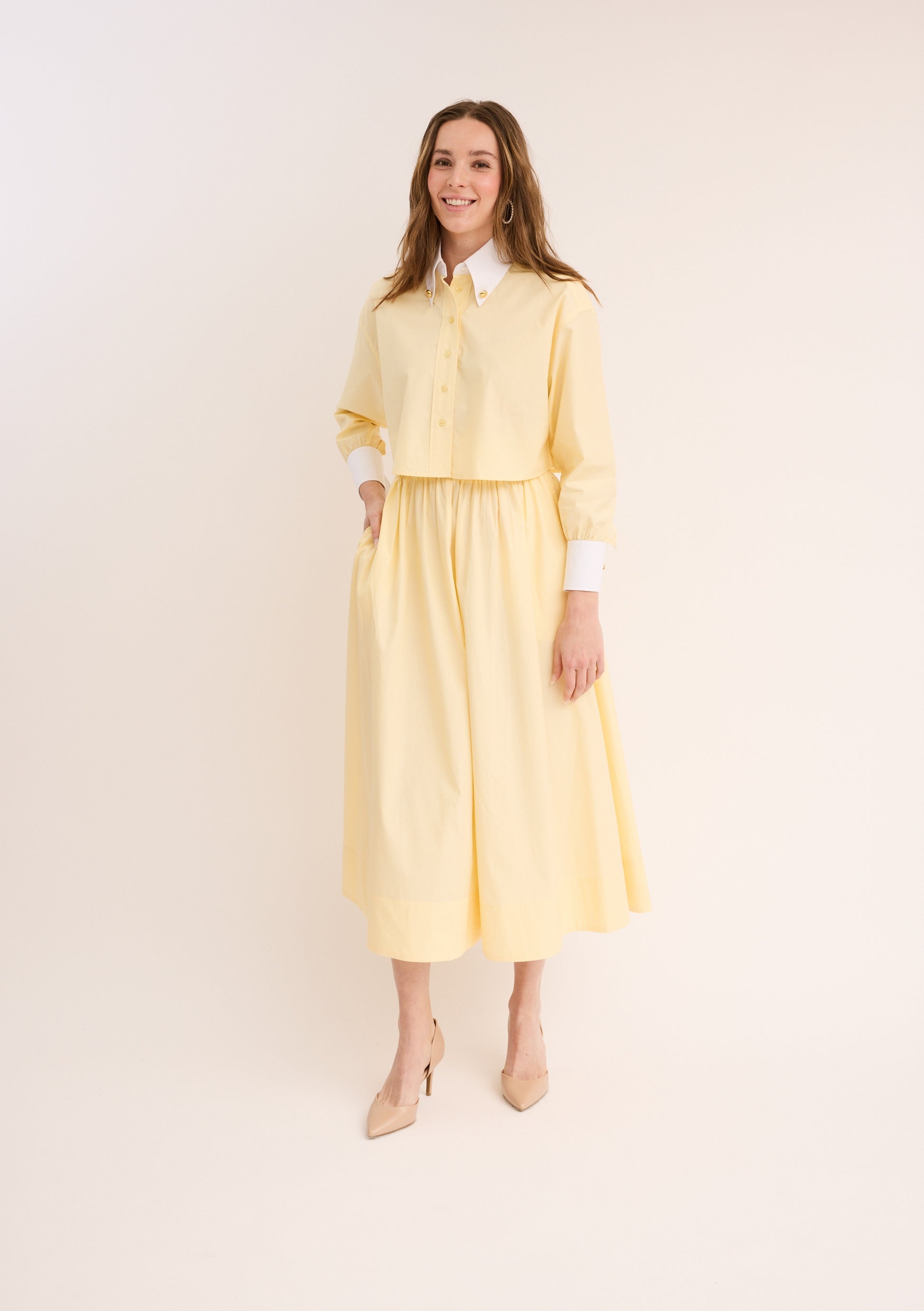 Woman wearing the yellow Cropped Poplin Contrast Collar Shirt with matching skirt.