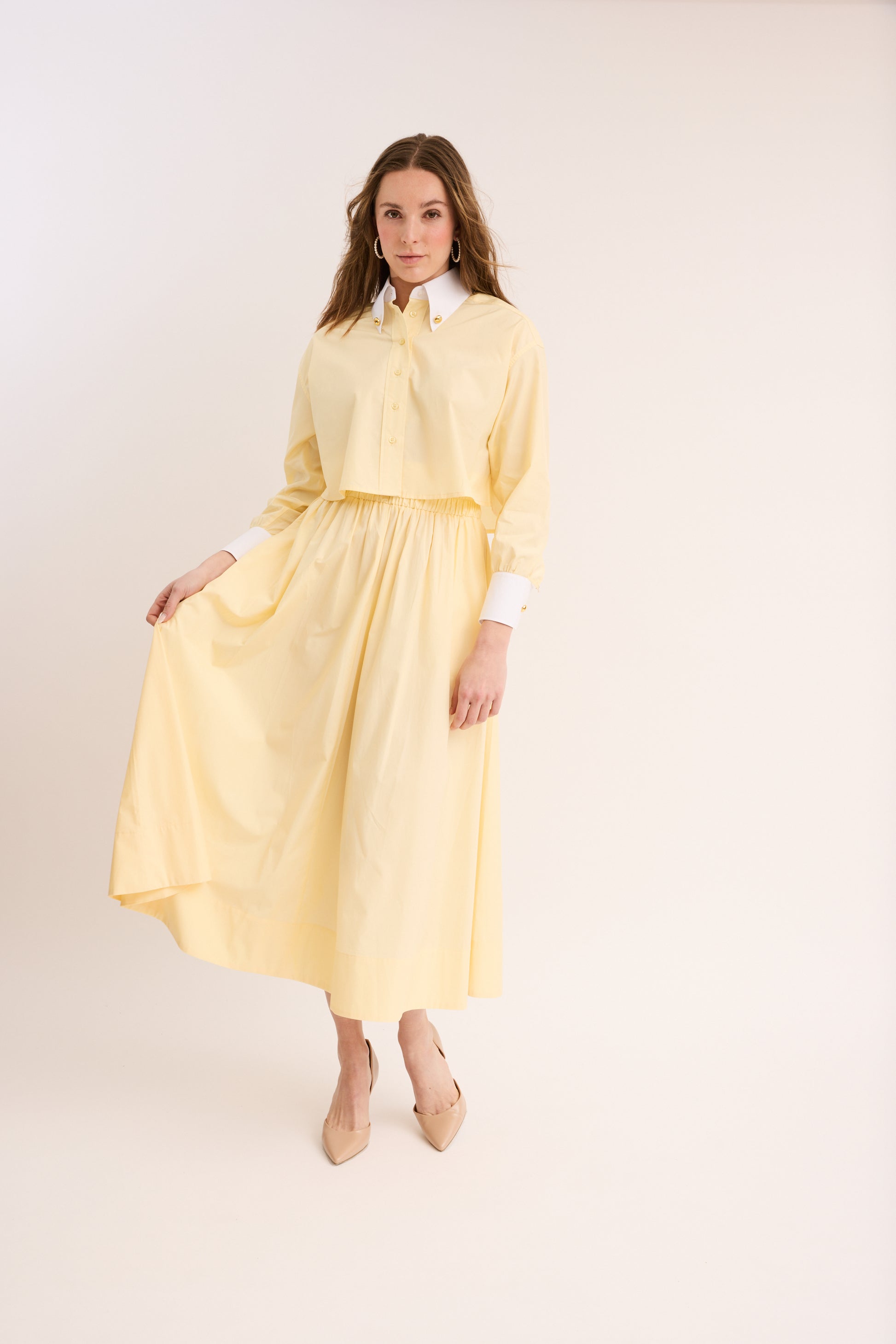 Woman wearing the yellow Cinched Poplin Skirt with matching top.