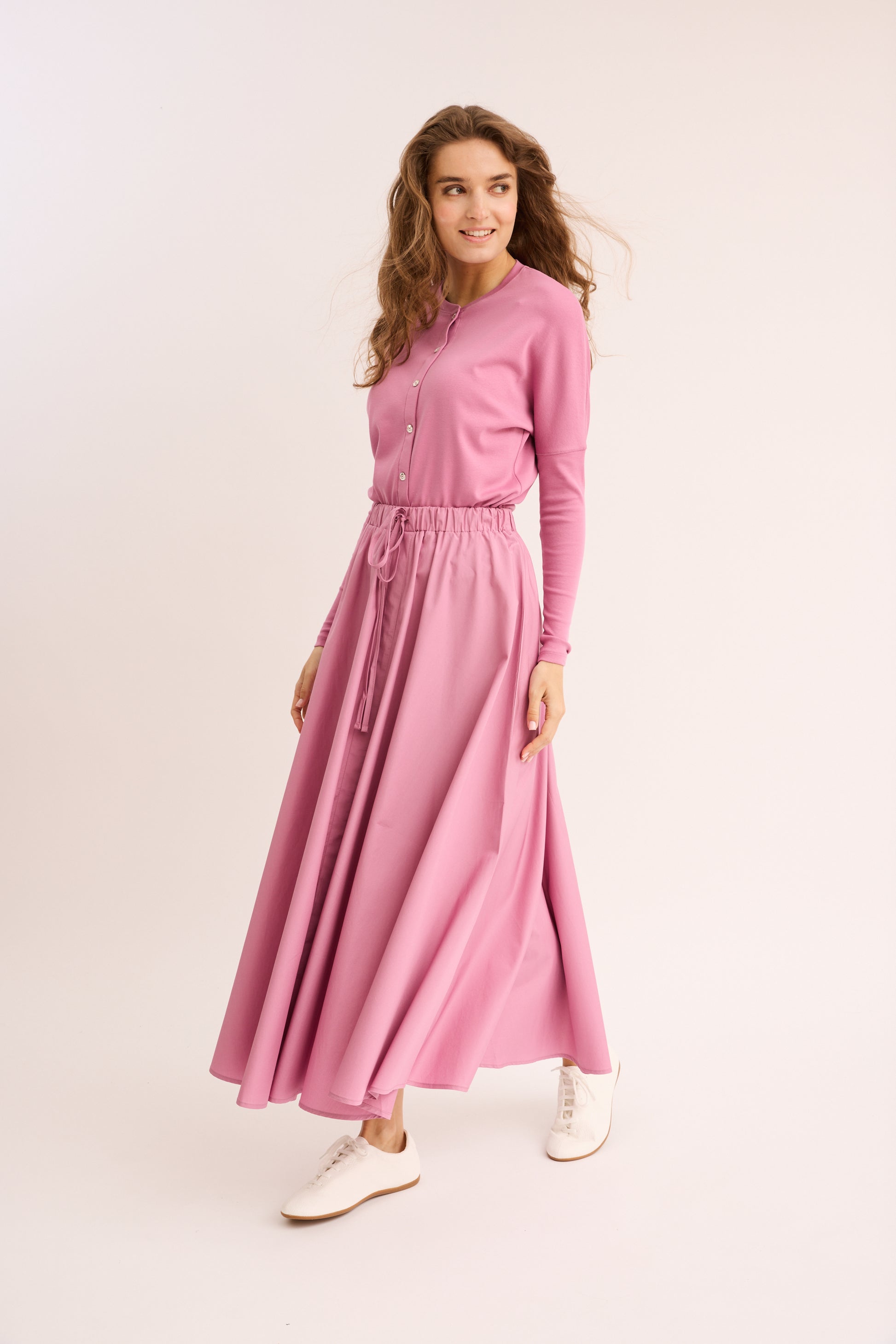 Woman wearing the deep rose Rhinestone Mock Cardigan Dolman with matching skirt. 