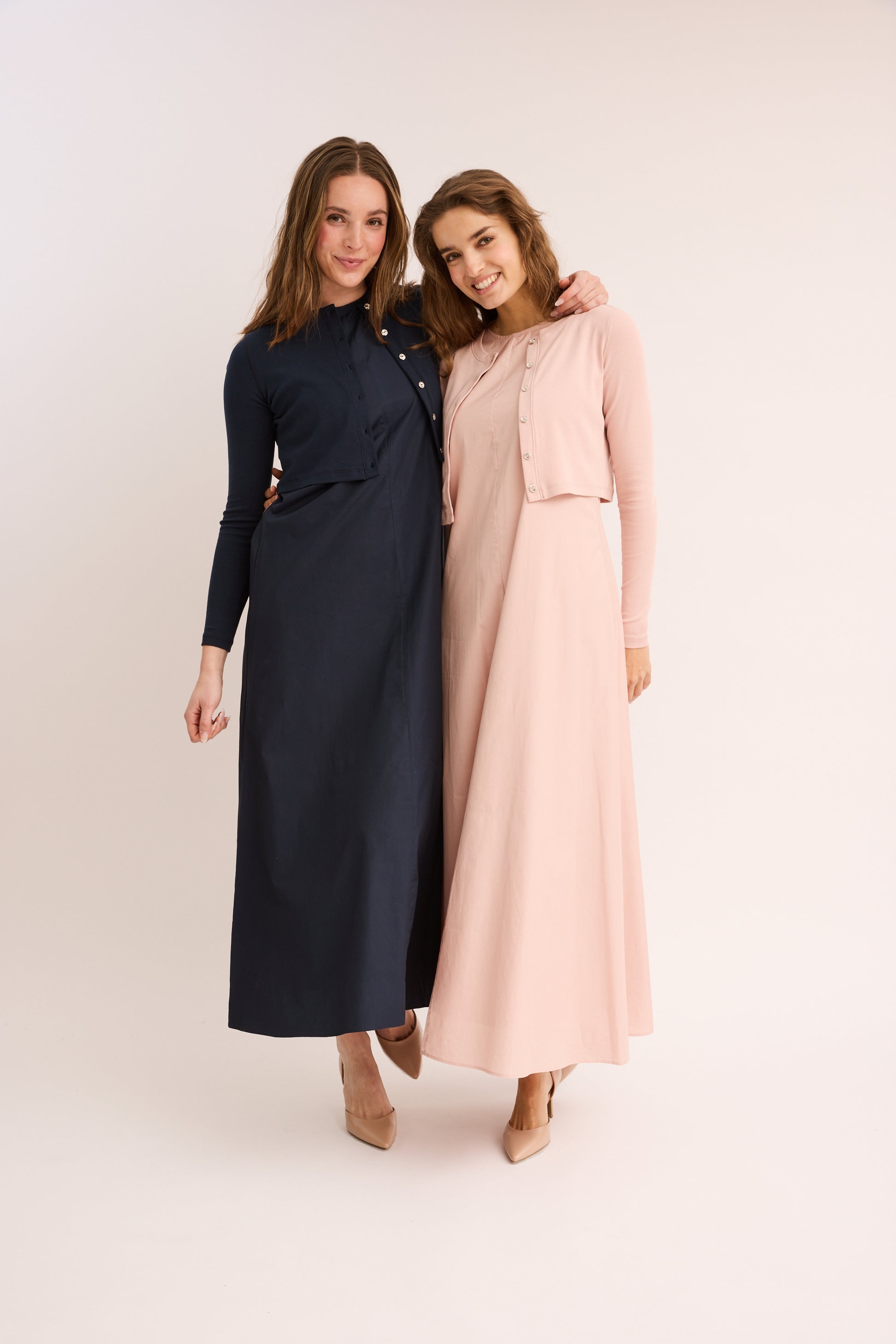 Women wearing the navy and blush Sleeveless Poplin Maxi Dresses.