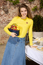 Woman wearing a yellow tee with Denim skirt.