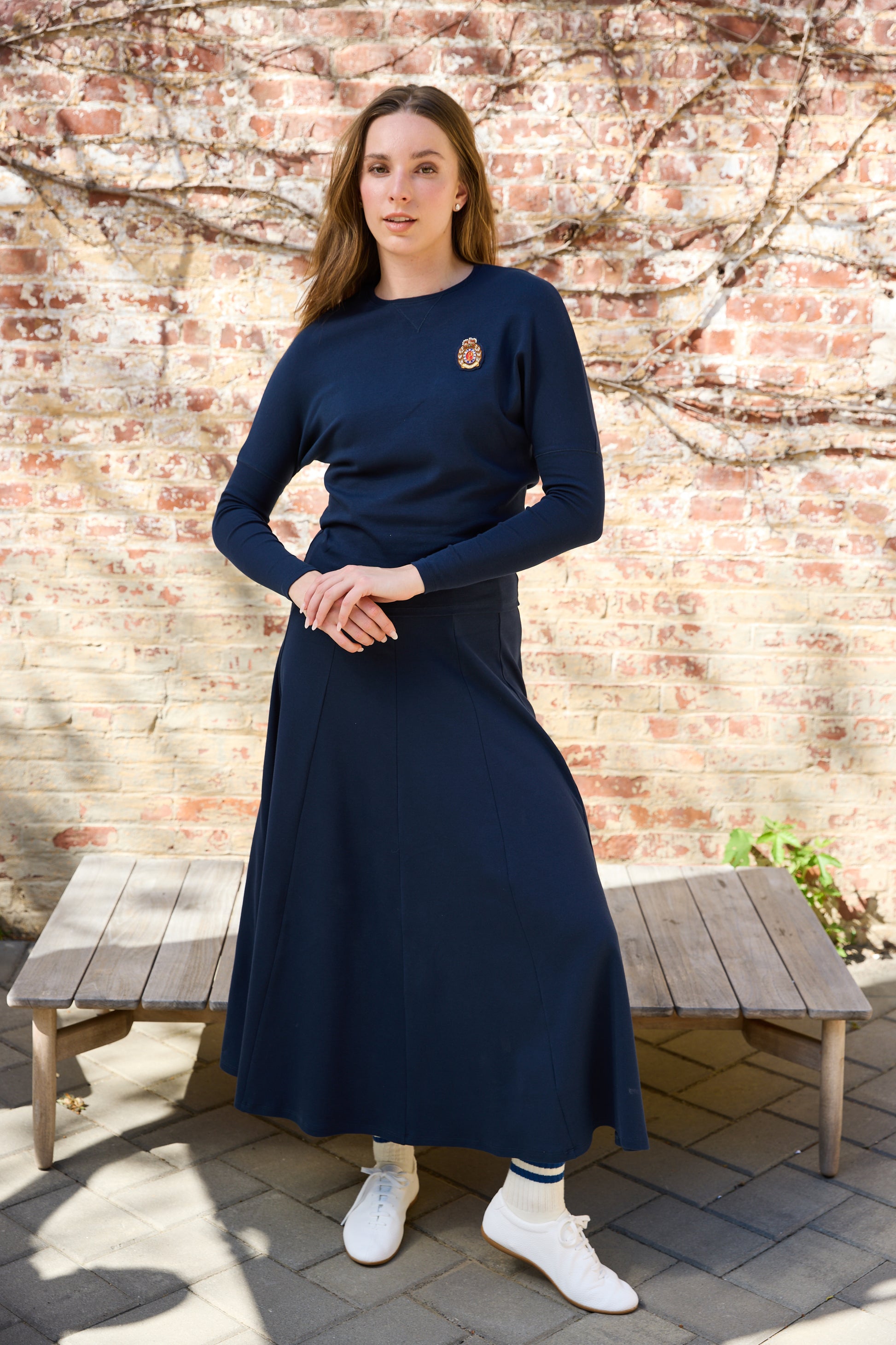 Woman wearing the navy Classic Parni Emblem Dolman Tee. 