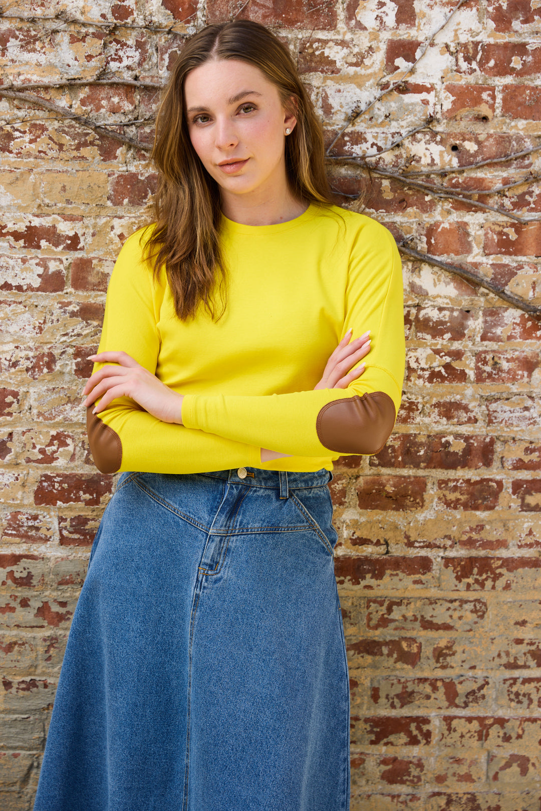 Woman wearing the yellow Elbow Patch Dolman Tee with Denim skirt. 