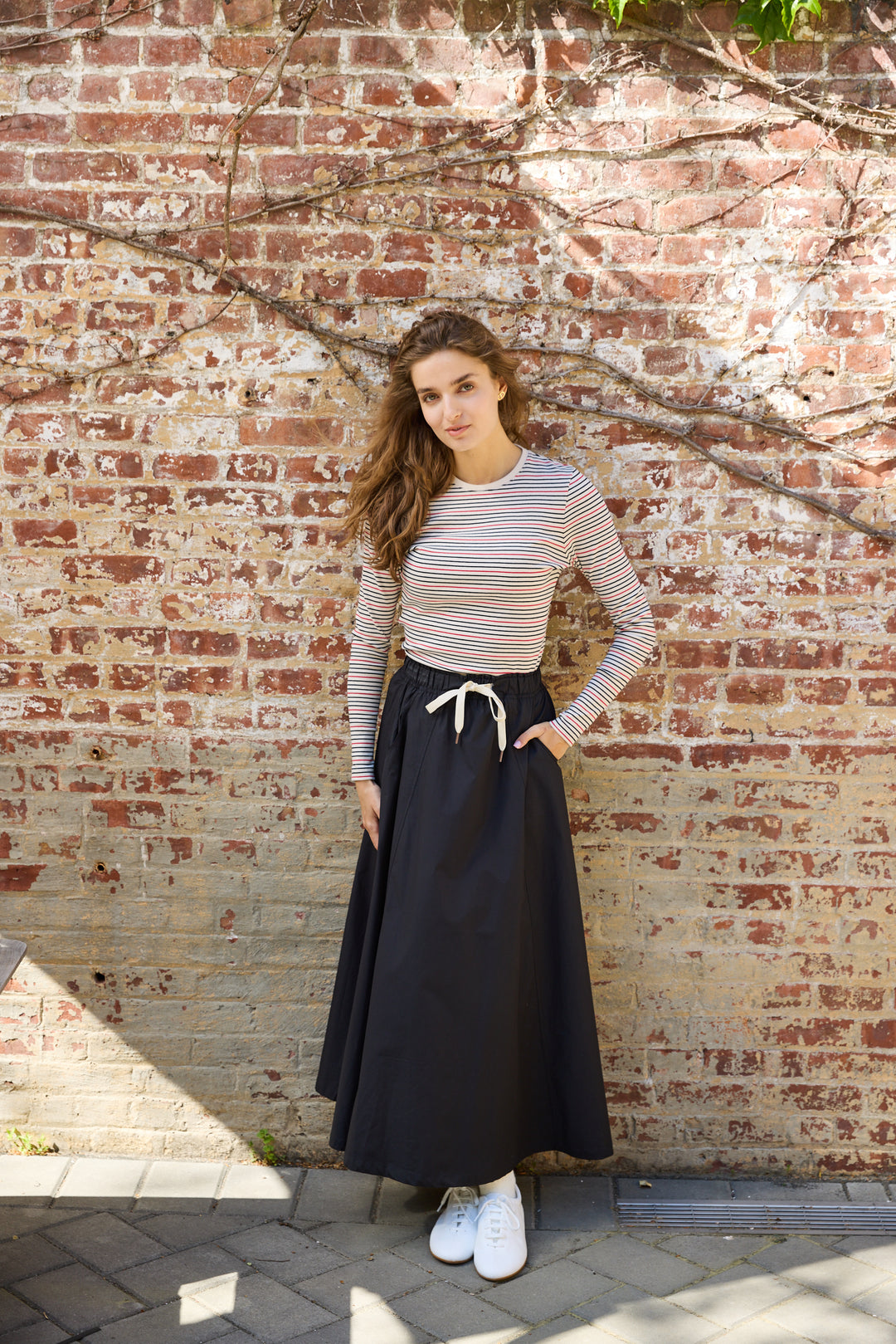 Woman wearing the The Perfect Twill Drawstring Skirt with multi striped Tee. 