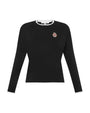 Black long-sleeve shirt with a small emblem on a white background