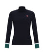 A women's long-sleeve mock neck top in black, featuring a small red and white logo patch on the left chest and contrasting green and white striped cuffs.