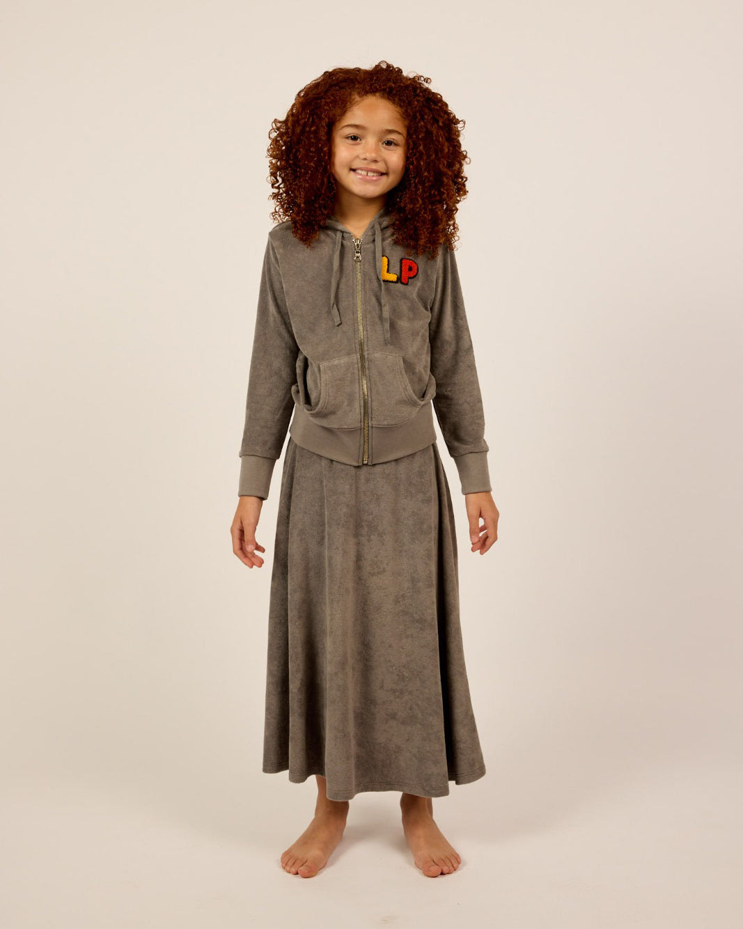 Model wearing the grey Girls French Terry Zip-Up Hoodie and Skirt Set.