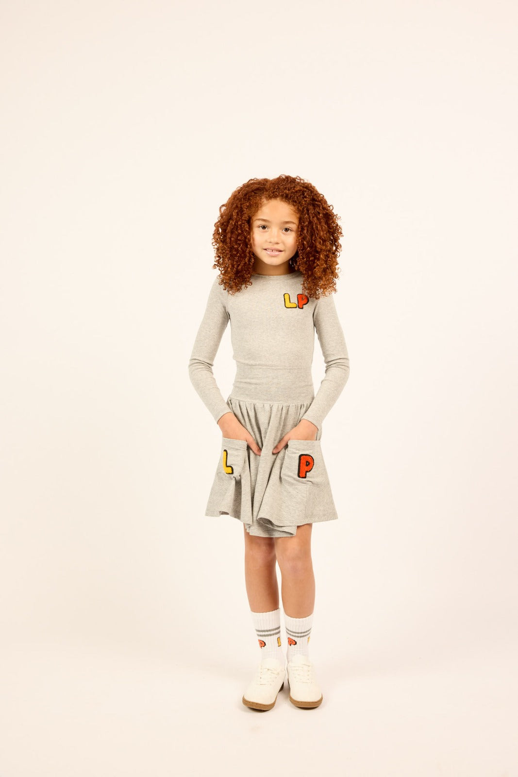Girl wearing the grey Girls High Waisted Varsity Skirt.
