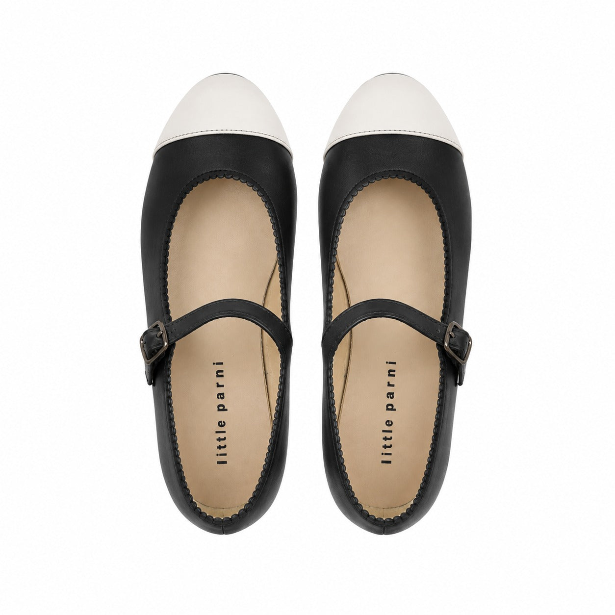 A pair of black leather Mary Jane flats with white pointed-toe caps, shown from a top-down view on a white background. The brand name 'little parni' is printed on the insoles.