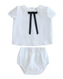 White baby outfit with a bow tie on a white background