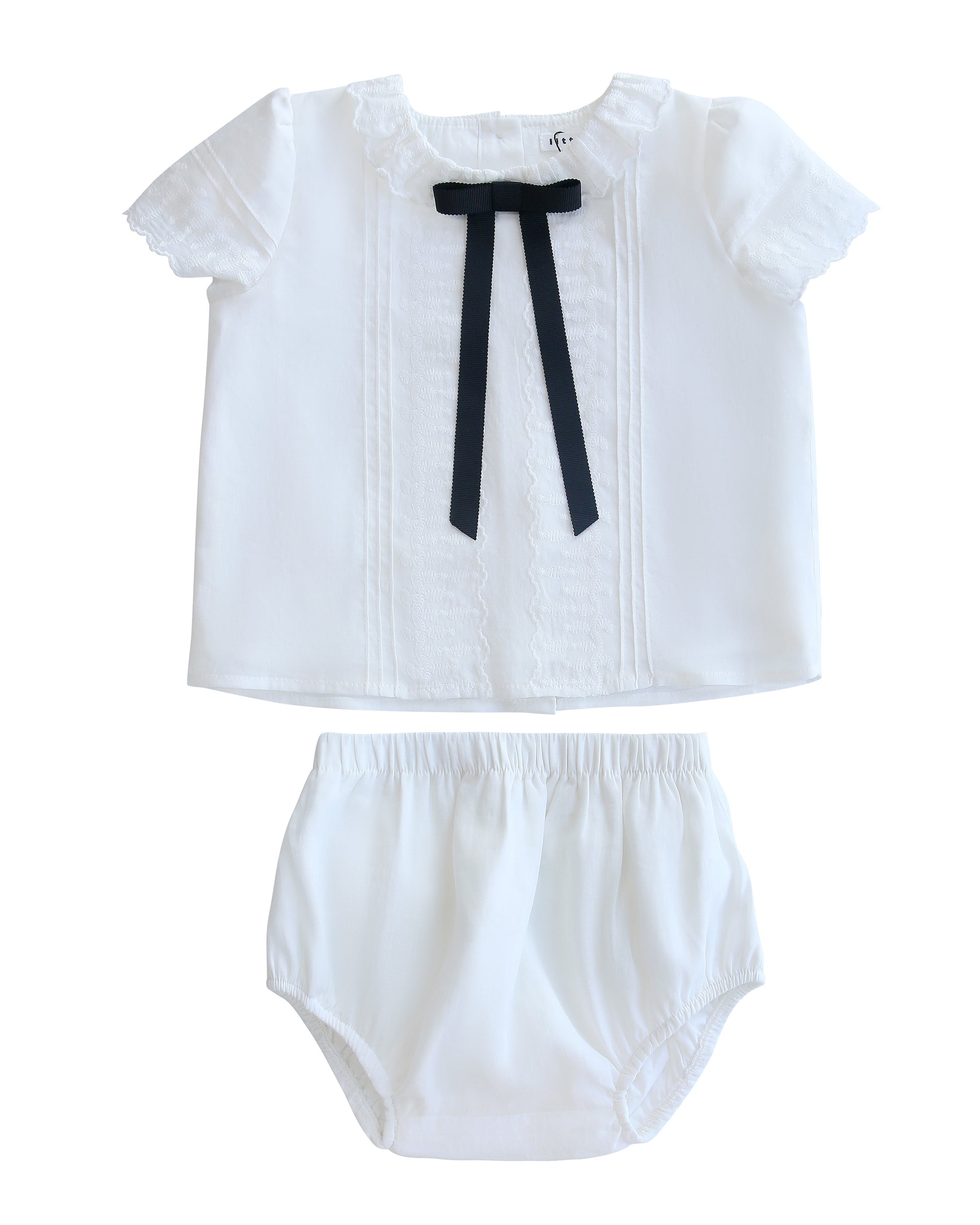 White baby outfit with a bow tie on a white background